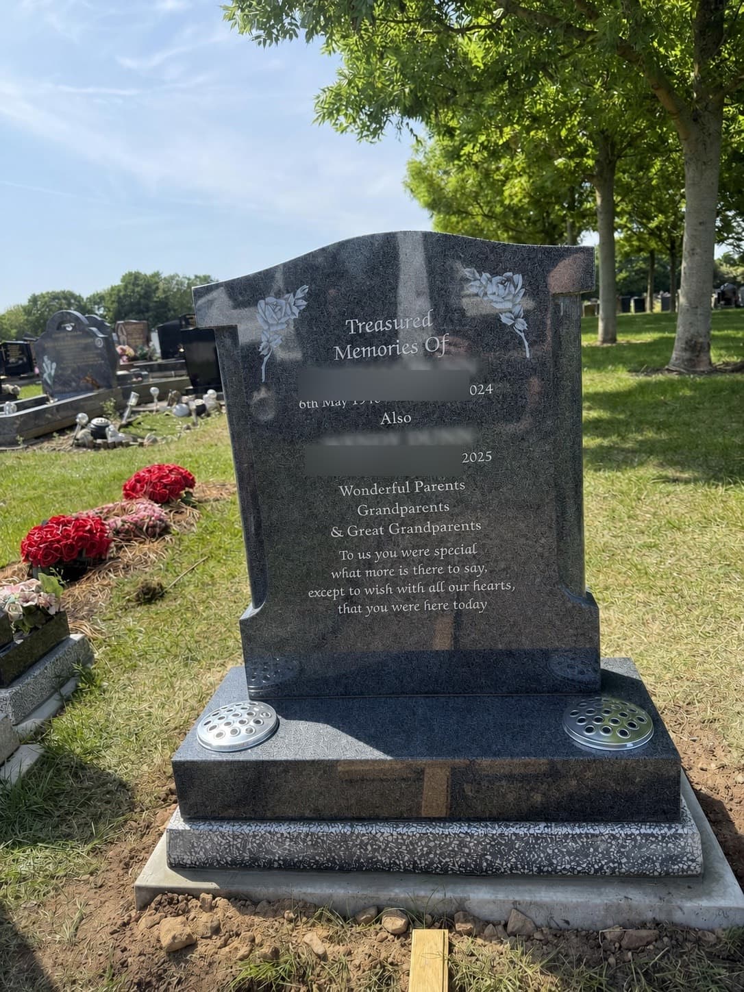 Dark granite memorial with carved roses
